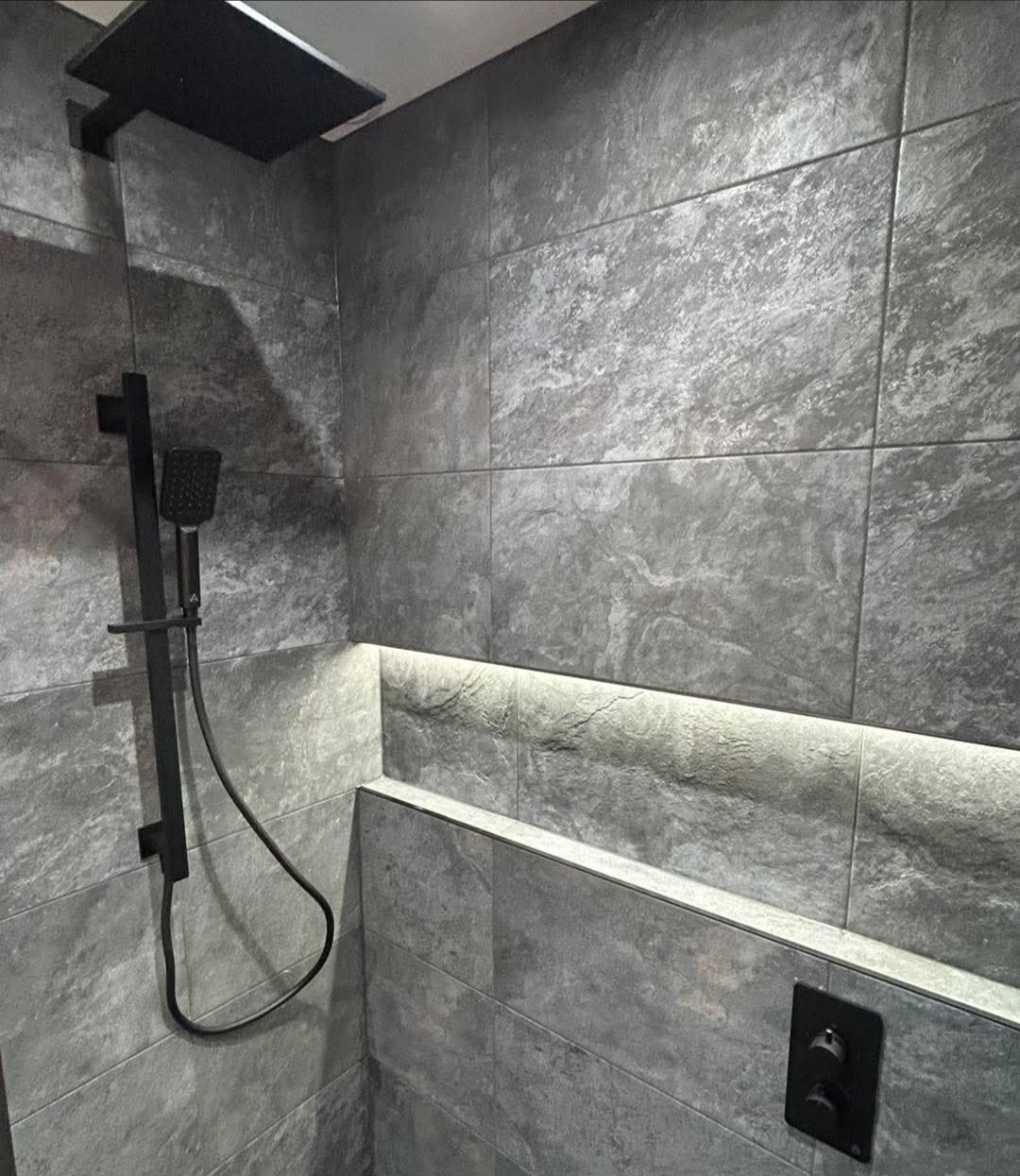 Walk-in shower with textured grey tiling and chrome fittings fitted in a shower room in Kirkcaldy